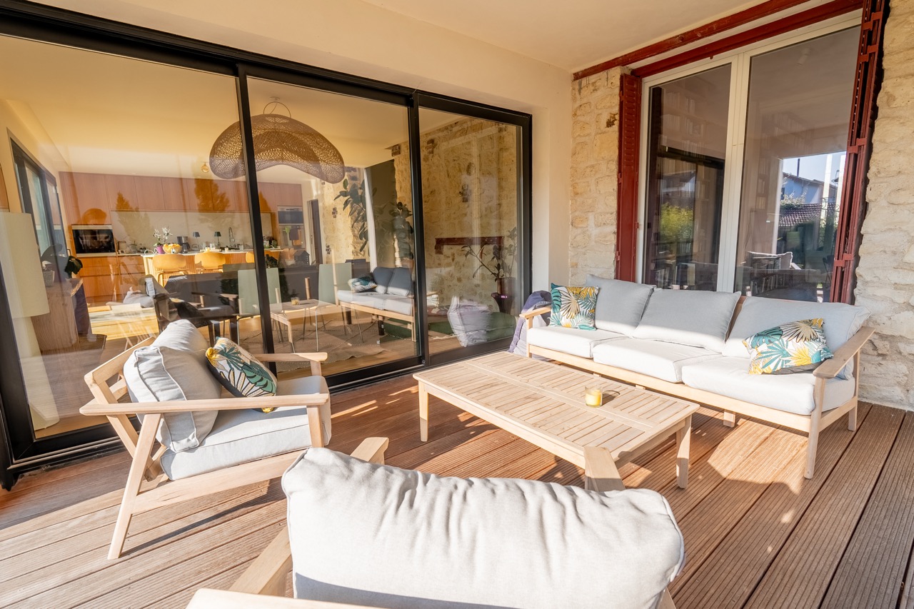 DLaonTkX3z9ar4JHSBnNb427N8hTbhksMhjOWQjt.jpg salon d'extérieur en bois avec coussins blancs